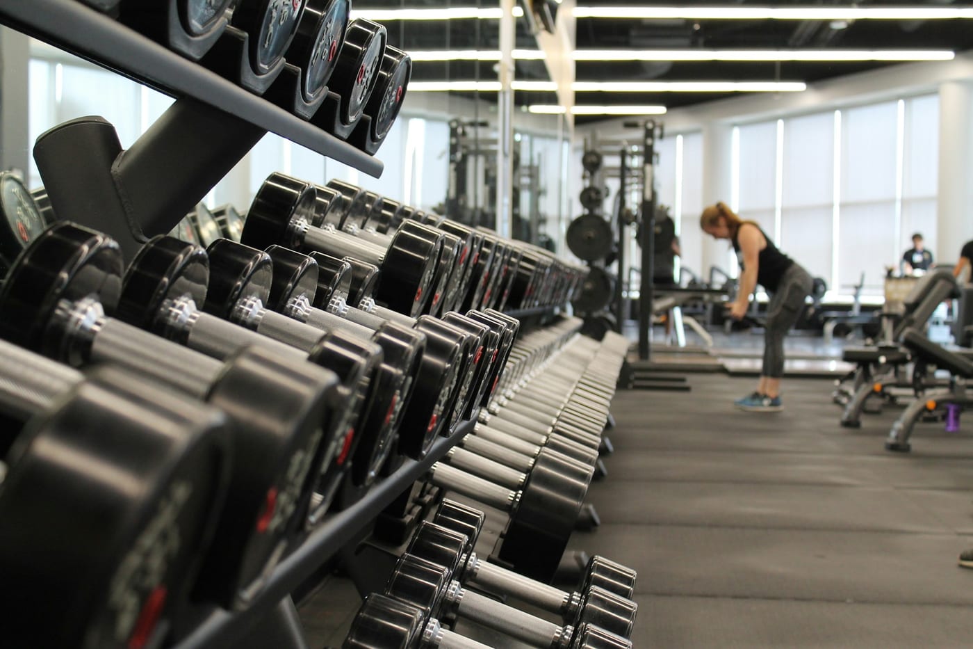 A dark, atmospheric gym with heavy weights and iron equipment, dimly lit to create a focused atmosphere.